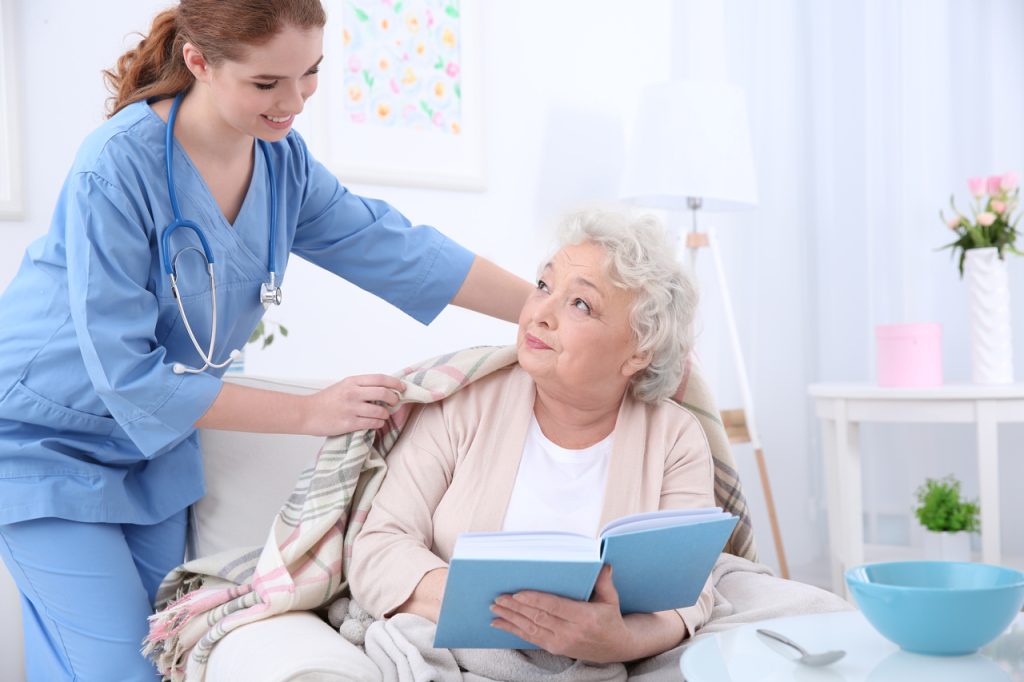 Caregiver helping elderly patient at home